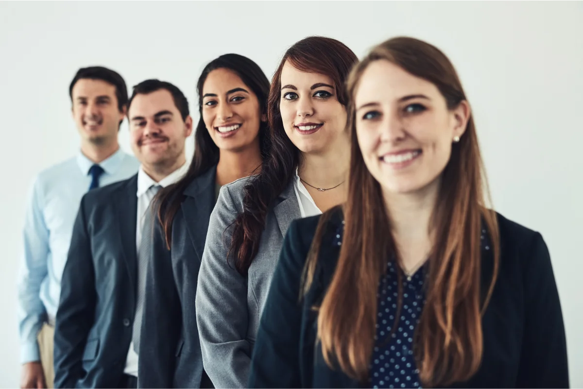 Cinco ocmpañeros de trabajo mirando a cámara
